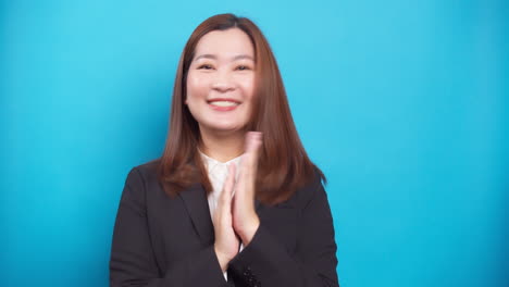 Retrato-De-Una-Mujer-De-Negocios-Asiática-Positiva-Sonriendo-Y-Exitosa-Con-Un-Aplauso-De-Felicitación-Por-El-Fondo-Azul