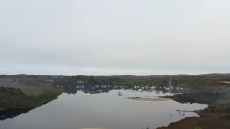 Aerial:-Drone-tracking-to-the-left-around-a-harbour-full-of-boats-in-Tasmania,-Australia