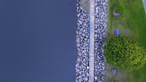 Una-Pista-A-Vista-De-Pájaro-Sobre-El-Paseo-Marítimo-De-Piedra-En-El-Lado-Sur-Del-Canal-Muskegon