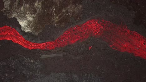 Aerial-top-view-over-a-lava-river-flowing-across-Meradalir-valley,-Iceland,-erupting-out-of-Fagradalsfjall-volcano