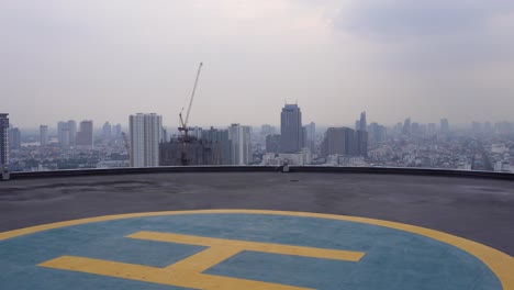 A-helipad-is-located-on-top-of-the-Hilton-building-in-Bangkok,-with-beautiful-skyscrapers-in-the-background