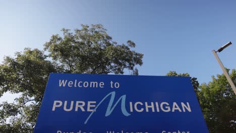 Pure-Michigan-welcome-sign-in-Dundee,-Michigan-with-gimbal-video-tilting-down-in-slow-motion