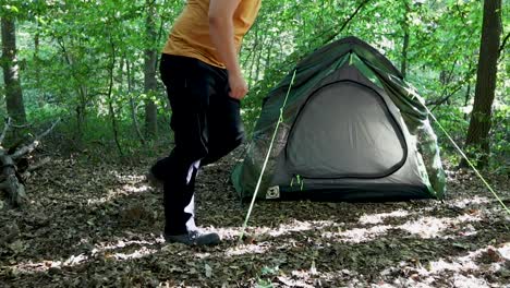Tourist-man-adjusting-the-tent-at-a-campsite-in-the-woods-1