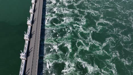 Aerial-tilt-down-shot-of-storm-surge-barrier-Oosterschelde-in-Zeeland-during-sunny-day