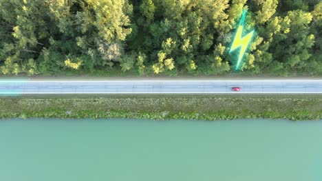 Red-electric-car-driving-fast-on-straight-road-with-pine-tree-forest-and-water-lake