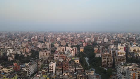 Endless-cityscape-of-Dhaka-city-with-light-smog,-aerial-fly-forward-view