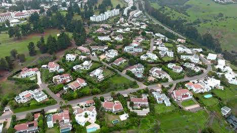 Drone-flyover-exclusive-houses-among-lush-gardens-Landscape-in-Maitencillo,-Chile