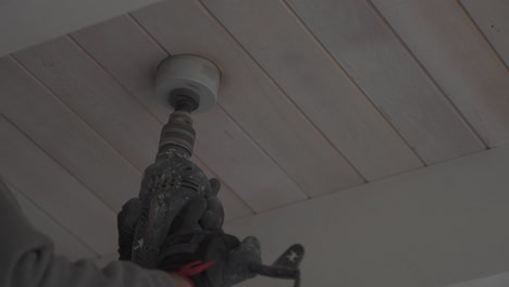 Close-up-of-worker-making-a-hole-in-a-white-ceiling-using-a-drill-hole-saw--slow-motion