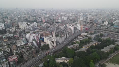 Highway-road-leading-through-Dhaka-city-downtown,-aerial-orbit-view