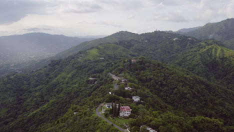 Luftaufnahme-Des-Skyline-Drive-In-Kingston-Jamaika-Mit-Blick-Auf-Die-Stadt-Und-Die-Ansicht-Von-Kingston-Town-Erscheint,-Wenn-Sich-Das-Bild-Dreht