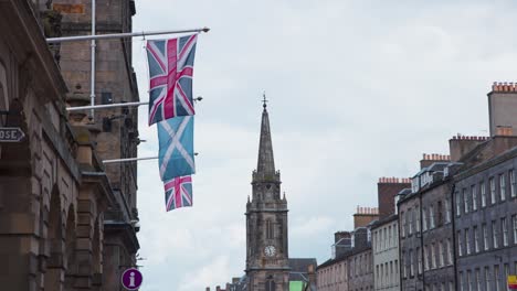 British-and-Scottish-flags-on-facade-flagpoles,-Royal-Mile,-Edinburgh