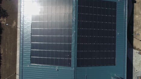 Ascending-top-view-of-sun-shining-on-futuristic-solar-panel-installed-on-roof-of-building-on-farm
