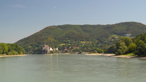 Passing-down-slowly,-big-Danube-river-on-clear-summer-day