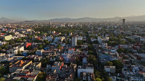 Mexico-City-Aerial-v12-cinematic-dolly-in-shot,-drone-flying-south-across-roma-norte-neighborhod-capturing-populous-urban-cityscape-at-sunset---Shot-with-Mavic-3-Cine---December-2021