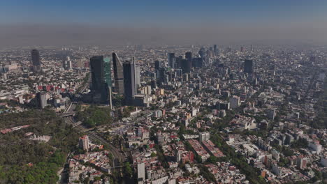 Mexico-City-Aerial-v50-dolly-in-shot-drone-flyover-la-condesa,-juarez-and-roma-norte-neighborhoods-capturing-densely-populated-downtown-cityscape-on-a-hazy-day---Shot-with-Mavic-3-Cine---December-2021