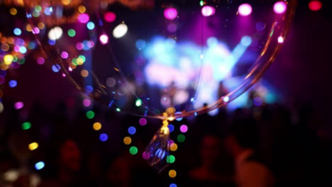 Close-up-of-glowing-led-balloon,-musical-band-performing-in-background