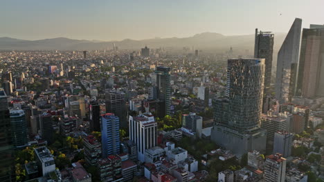 Mexico-City-Aerial-V17-Panoramaschwenkaufnahme,-Die-Das-Stadtbild-Der-Innenstadt-Mit-Wunderschönem-Sonnenlicht-Erfasst,-Das-Bei-Sonnenuntergang-über-Die-Nachbarschaft-Fällt-–-Aufgenommen-Mit-Mavic-3-Cine-–-Dezember-2021