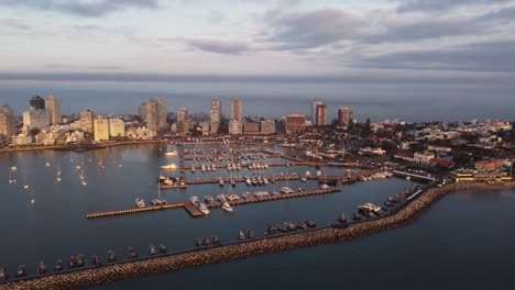 Spektakuläre-Filmaufnahmen-Der-Skyline-Von-Punta-Del-Este-In-Uruguay-Bei-Sonnenuntergang-Mit-Hafen-Und-Angedockten-Yachten