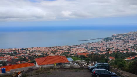 Pan-right-aerial-view-of-the-city-of-Funchal-and-the-coast-of-the-Atlantic-Ocean,-Madeira-island-in-Portugal