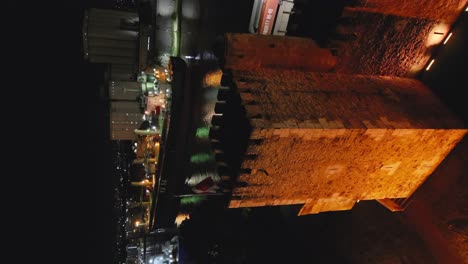 Toma-Vertical-Aérea-Del-Castillo-De-La-Fortaleza-De-Ozama-En-La-Noche-En-Santo-Domingo,-República-Dominicana