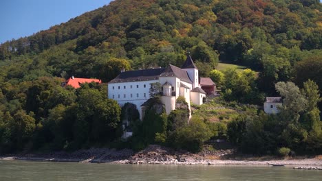 Wunderschönes-Weißes-Schloss-Auf-Einer-Natürlichen-Klippe,-Wie-Von-Der-Donaukreuzfahrt-Aus-Gesehen