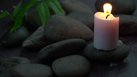 Eine-Kerze,-Die-Auf-Felsen-Mit-Einem-Vereinbarten-Blatt-Brennt,-Um-Eine-Spirituelle-Umgebung-Zu-Schaffen