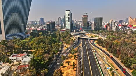 Mexico-City-Aerial-V93-Drone-Fliegt-Entlang-Einer-Mehrspurigen-Straße-Zwischen-Hochhäusern-Und-Vierteln,-Die-Zu-Einer-Wunderschönen-Endlosen-Skyline-Im-Stadtbild-Führen---Aufgenommen-Mit-Mavic-3-Cine---Januar-2022