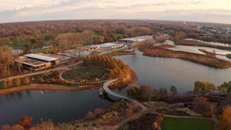 Glencoe,-Illinois,-USA-:-Aerial-drone-forward-moving-shot-over-new-building-constructed-inside-Chicago-Botanic-Garden-with-small-lakes-during-evening-time