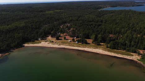 Aerial-view-in-front-of-the-Degersand-beach,-summer-in-Aland,-Finland---descending,-tilt,-drone-shot