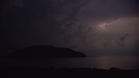 Summer-thunderstorm-in-night-dark-sky-with-clouds-over-an-island