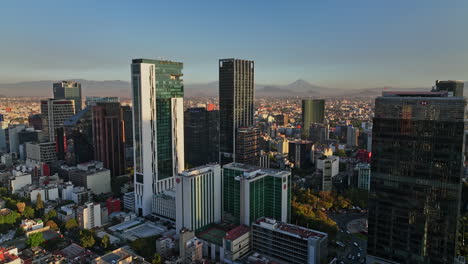 Mexico-City-Aerial-v18-cinematic-reverse-flyover-colonia-cuauhtemoc-neighbohood-capturing-fast-development-of-downtown-skyscrapers-cityscape-at-sunset---Shot-with-Mavic-3-Cine---December-2021