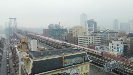 Slow-motion-static-drone-trains-over-Williamsburg-Bridge-Brooklyn-New-York-City