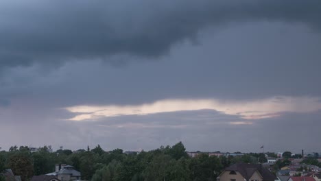 Time-lapse-of-fast-moving-dramatic-dark-thunderstorm-clouds-moving-over-the-city-skyline,-overcast-summer-evening,-wide-angle-shot