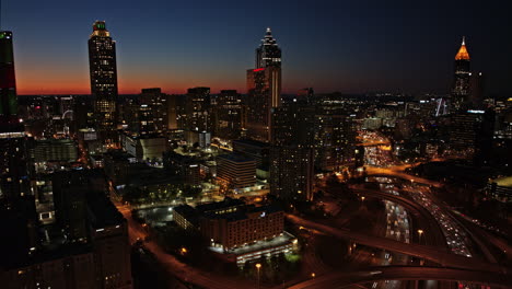 Atlanta-Aerial-v804-hyperlapse-flyover-sweet-auburn-capturing-busy-freeway-traffic-trails-and-downtown-cityscape-with-radiance-sunset-sky-view-to-dusk---Shot-with-Mavic-3-Cine---December-2021
