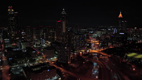 Atlanta-Aerial-V785-Flyover-Pull-Out-Shot,-Das-Den-Geschäftigen-Autobahnverkehr-Und-Das-Nächtliche-Stadtbild-Der-Innenstadt-Des-Modernen-Viertels-Mit-Beleuchteten-Hochhäusern-Einfängt---Aufgenommen-Mit-Mavic-3-Cine---Dezember-2021