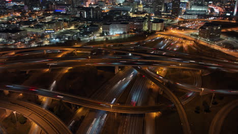 Atlanta-Aerial-v814-birds-eye-view-overlooking-at-busy-and-complex-freeway-traffics,-tilt-up-reveals-illuminated-futuristic-downtown-cityscape-at-night---Shot-with-Mavic-3-Cine---December-2021