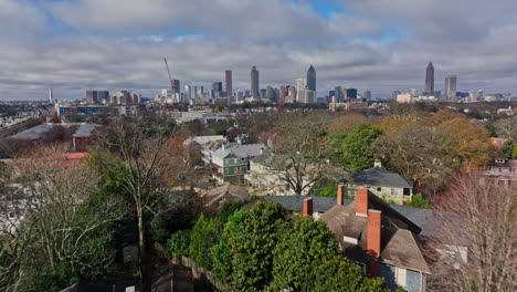 Atlanta-Aerial-v778-low-level-flyover-train-tracks-across-inman-park-residential-neighborhood-along-beltline-trail-with-downtown-cityscape-in-the-background---Shot-with-Mavic-3-Cine---December-2021