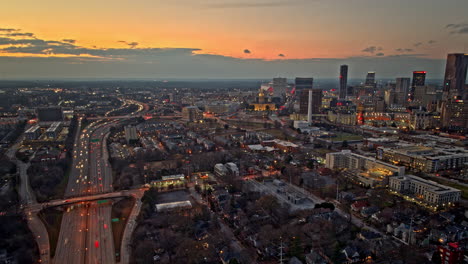 Atlanta-Aerial-v818-hyperlapse-panning-above-grant-park,-capturing-downtown-cityscape-at-central-business-district-and-busy-freeway-traffic-trails-at-sunset---Shot-with-Mavic-3-Cine---December-2021