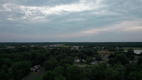 Aerial-drone-forward-moving-shot-over-small-town-in-Ohio,-USA-during-sunset-on-a-cloudy-day