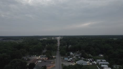 Aerial-drone-over-a-main-road-along-with-bylanes-in-a-small-town-at-sunset-in-Ohio,-USA