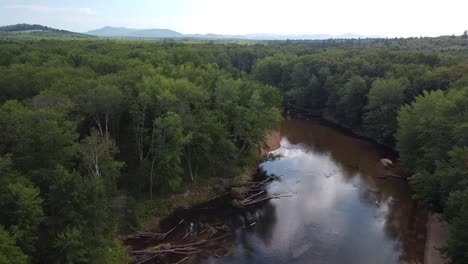 Drone-shot-of-a-mountains,-trees-and-sky-reflecting-in-a-bend-in-the-Saco-River-in-Fryeburg,-Maine