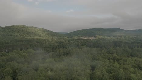 Drone-flying-through-a-beautiful-foggy-mountain-top-landscape,-over-a-river-1