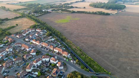 Drone-shot-of-a-blue-train-leaving-a-village-train-station-in-Aylesham-in-Kent