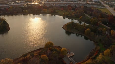 Glencoe,-Illinois,-USA-:-Aerial-tilt-up-shot-over-beautiful-lake-in-Chicago-Botanic-Garden-along-a-roadside-during-evening-time