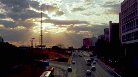 Urban-traffic-at-sunset-with-golden-sunbeams-shining-through-the-clouds