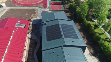 Solar-panels-on-a-school-rooftop-for-alternative,-clean-energy---aerial-view