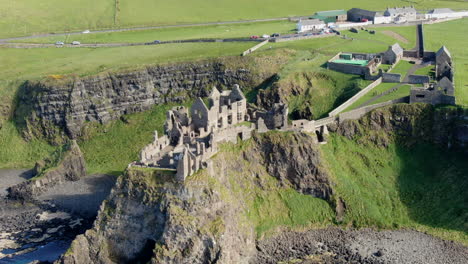Fantastic-aerial-shot-in-orbit-over-Dunluce-Castle-in-Ireland,-the-setting-for-the-Game-of-Thrones-series
