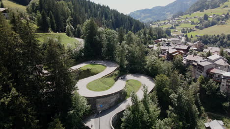 Aerial-panoramic-view-of-cars-descending-the-curvaceous-road-in-Steg-Hohtenn-in-Switzerland