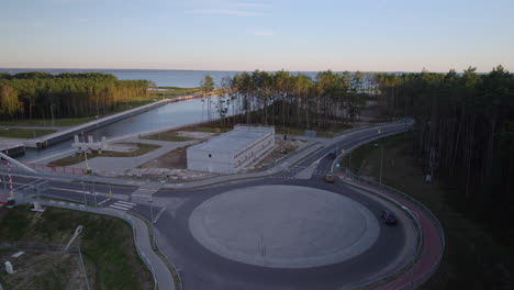 Aerial-view-of-cars-and-camper-driving-in-roundabout-at-Vistula-Spit-Canal-Nowy-Swiat,Poland