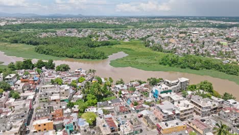 Aerial-panning-shot-of-neighborhood-in-Santo-Domingo-near-Rio-Ozama-River-during-sunny-day-on-Dominican-Republic